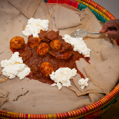 Doro Wotmit Frischkaese auf Injera serviert.