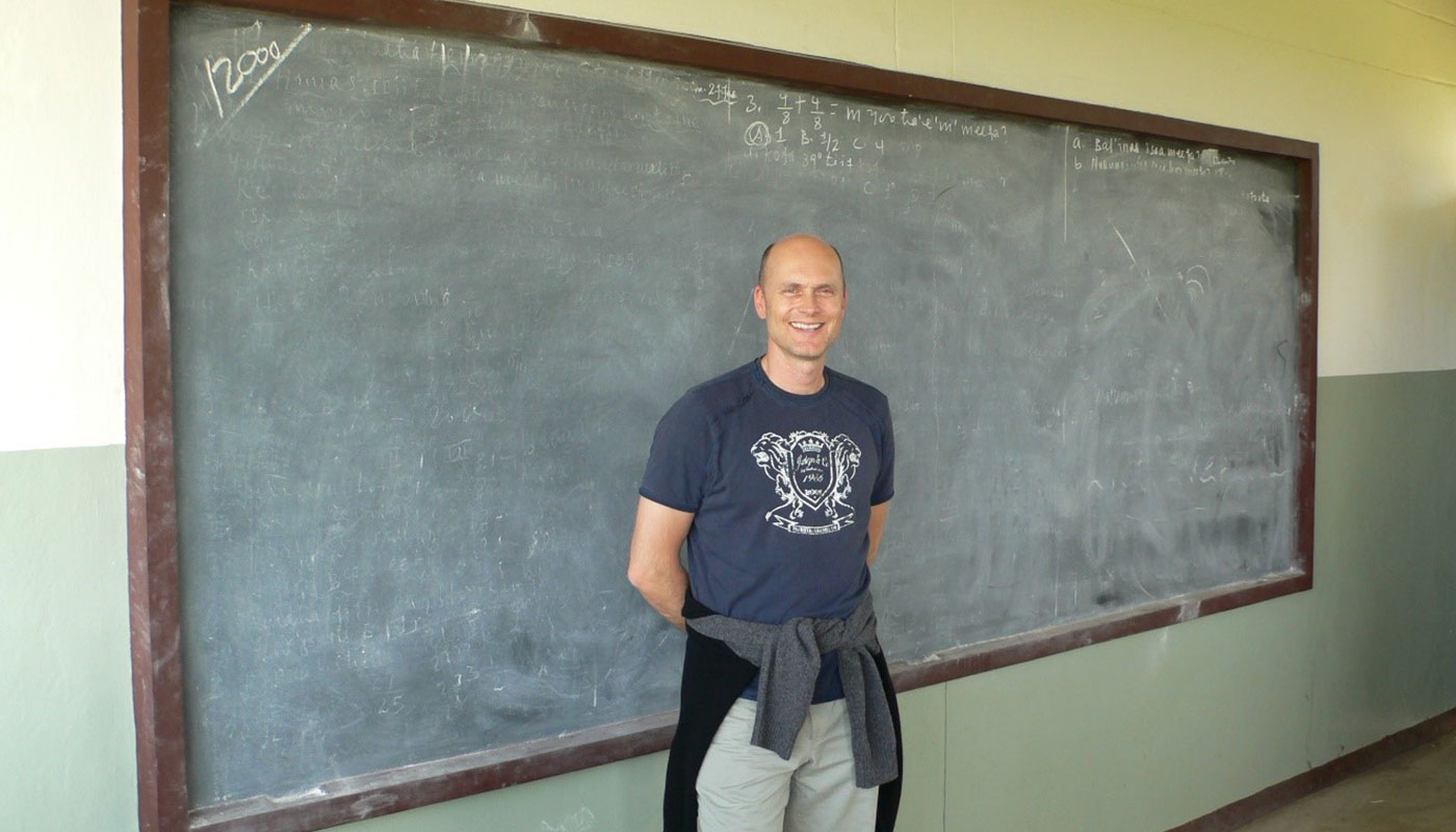 ein Mann steht vor der Tafel einer neu gebauten Schule in Äthiopien