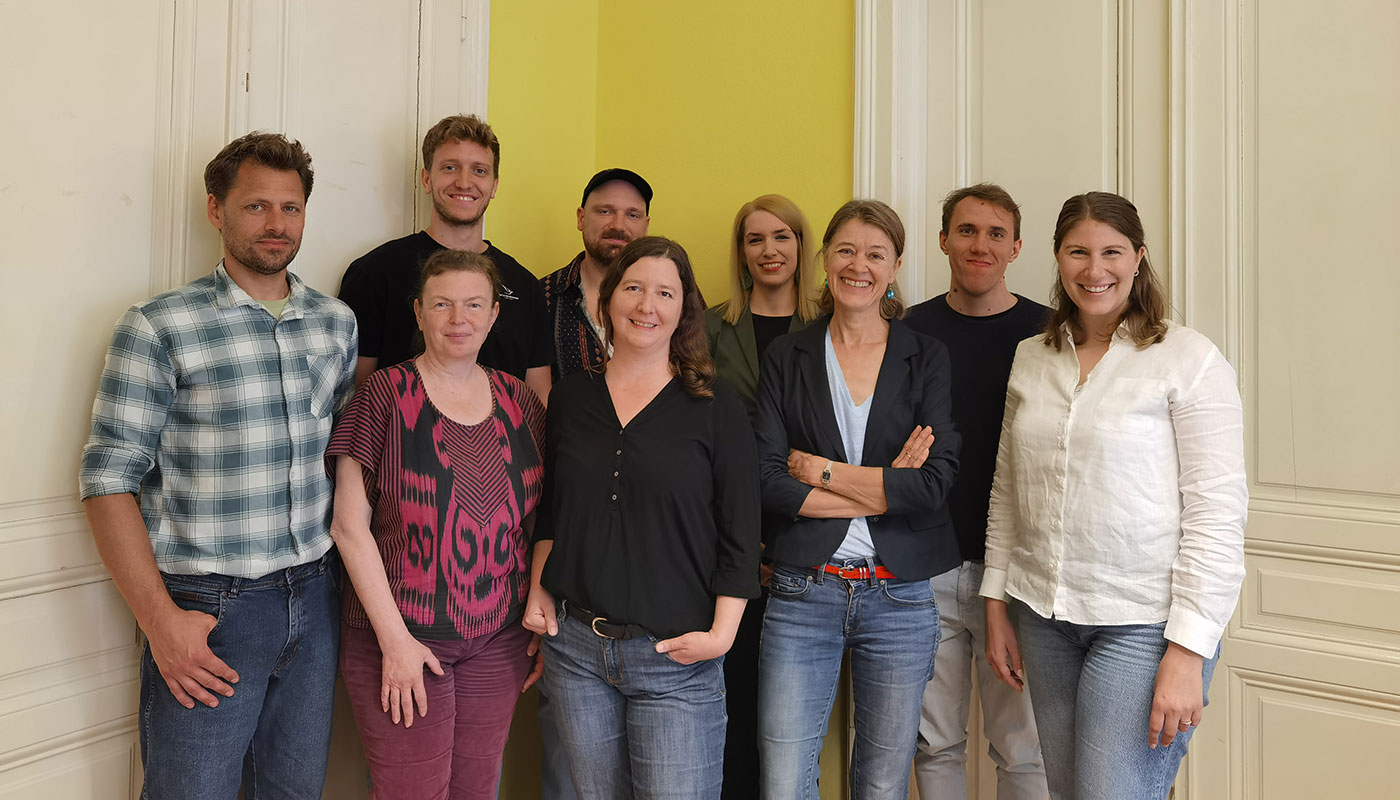 Gruppenfoto des Teams von Menschen für Menschen, bestehend aus 9 Personen, die in zwei Reihen zusammen stehen