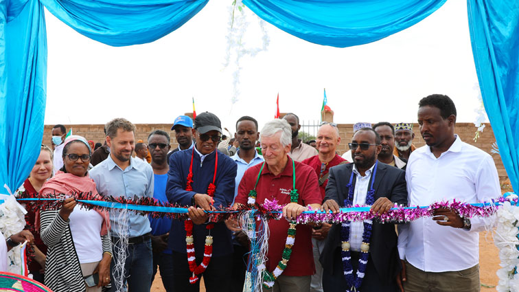 Peter Krasser schneidet zur feierlichen Eröffnung der Schule symbolisch ein Band durch.