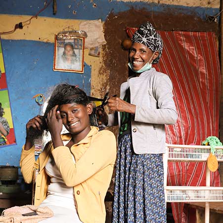 Friseurin in Äthiopien schneidet Haare einer Kundin