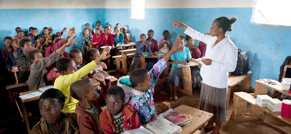 Eine äthiopische Lehrerin lehr Kinder welche gerade aufzeigen