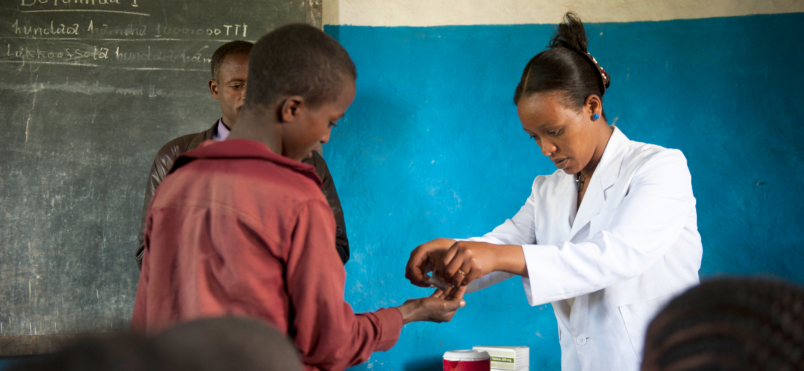 Eine äthiopische Ärztin verteilt Medikamente in einem Klassenzimmer