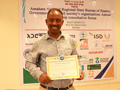 Addisu Assefa, Programmkoordinator hält eine Urkunde in der Hand